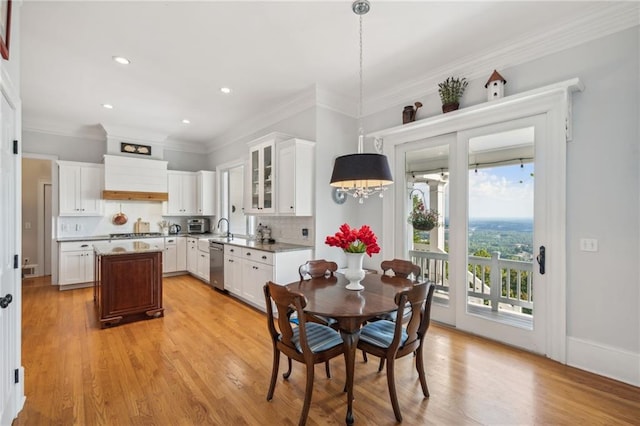 dining room with recessed lighting, baseboards, crown molding, and light wood finished floors