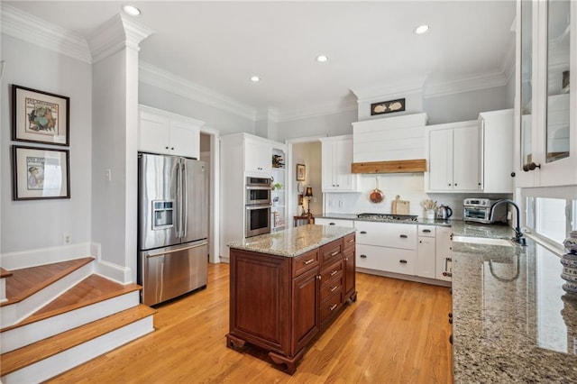 kitchen featuring crown molding, stainless steel appliances, light wood-type flooring, and white cabinets