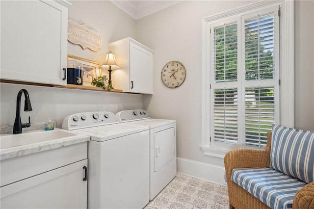 washroom with a sink, baseboards, washer and dryer, ornamental molding, and cabinet space