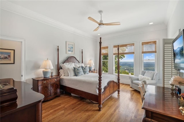 bedroom with light wood finished floors, ceiling fan, and ornamental molding