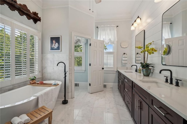 bathroom featuring marble finish floor, a healthy amount of sunlight, a sink, and crown molding