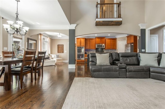 107 Estates At The Lake Dr, Canton, GA 30114 - living room featuring crown molding, a notable chandelier, dark wood finished floors, and arched walkways