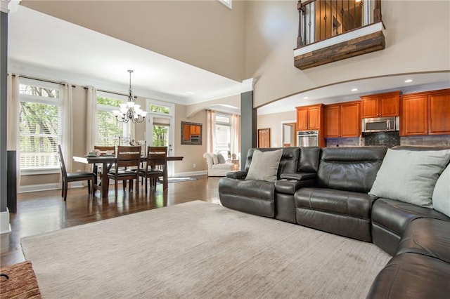 107 Estates At The Lake Dr, Canton, GA 30114 - living room with arched walkways, a notable chandelier, baseboards, and wood finished floors