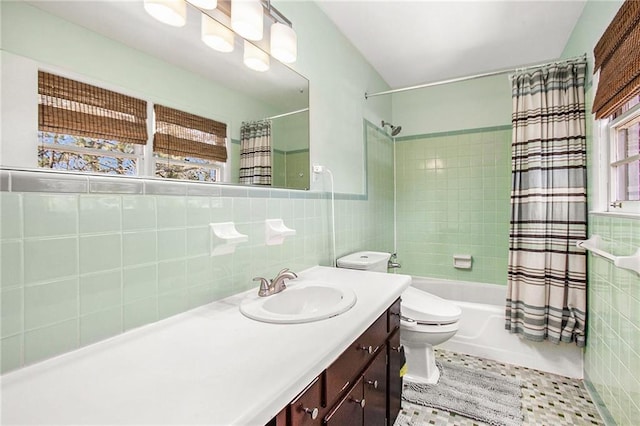 bathroom featuring tile patterned flooring, toilet, shower / tub combo, vanity, and tile walls