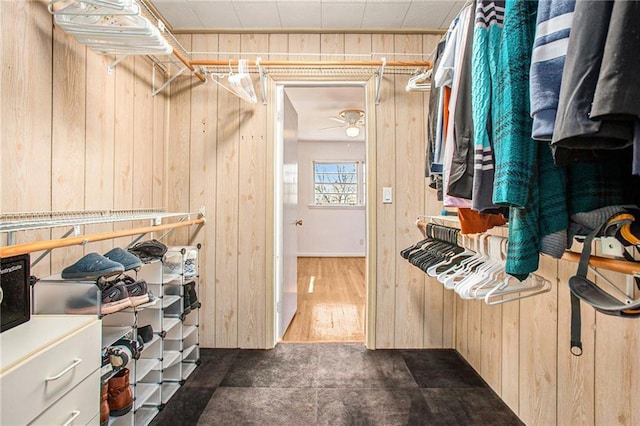 spacious closet with dark wood-style floors and ceiling fan