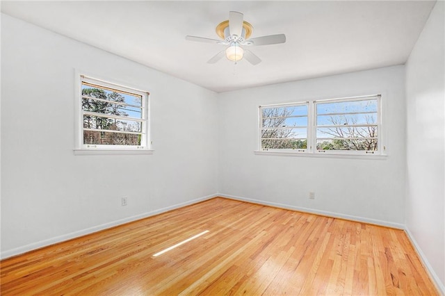 unfurnished room with ceiling fan, light wood-style flooring, and baseboards