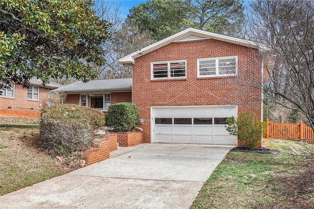 split level home with a garage, concrete driveway, brick siding, and fence