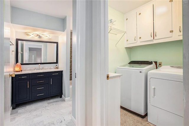 washroom featuring a sink, baseboards, marble finish floor, independent washer and dryer, and cabinet space