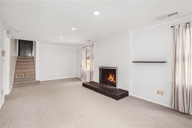 unfurnished living room featuring recessed lighting, a fireplace, visible vents, stairway, and carpet