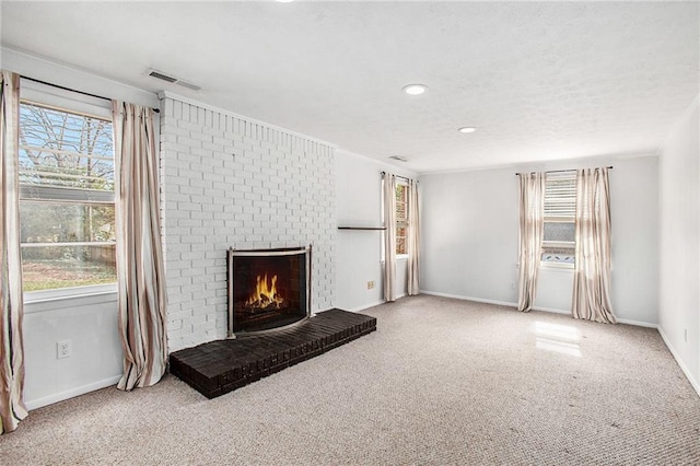 unfurnished living room with light carpet, baseboards, visible vents, a brick fireplace, and recessed lighting