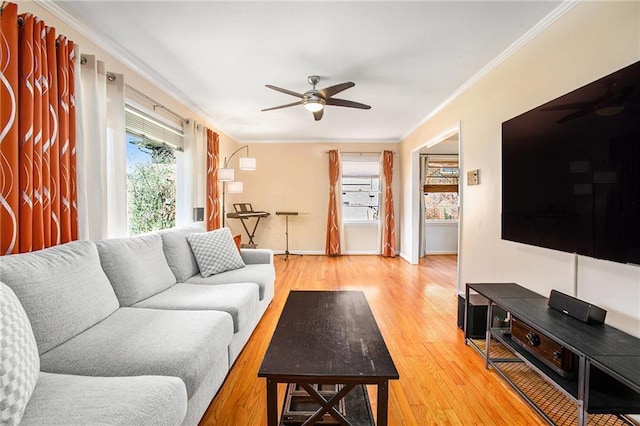 living area featuring ornamental molding, wood finished floors, a ceiling fan, and baseboards