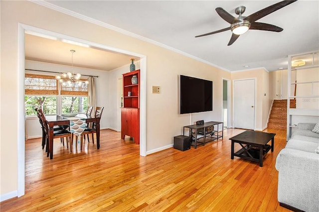 living area featuring light wood finished floors, stairway, ornamental molding, baseboards, and ceiling fan with notable chandelier