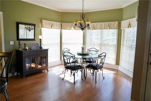 dining area with a notable chandelier, wood finished floors, and crown molding