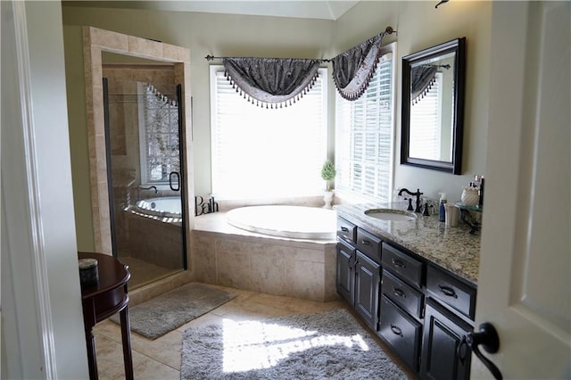 bathroom with tile patterned flooring, a shower stall, a garden tub, and vanity