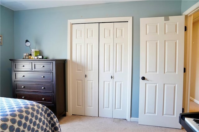 bedroom featuring light colored carpet and a closet