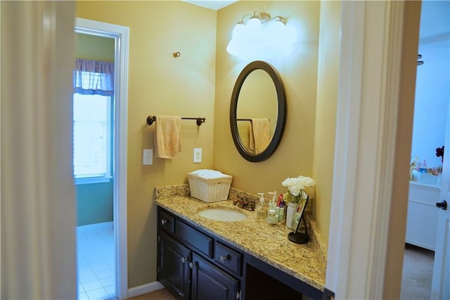 bathroom with a healthy amount of sunlight, vanity, and baseboards