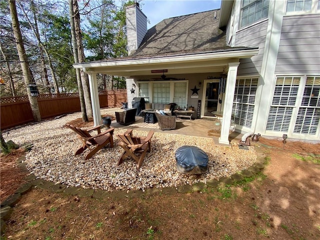 view of patio with an outdoor living space with a fire pit and fence