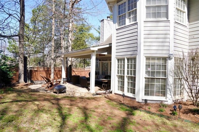 exterior space with a patio, outdoor lounge area, a chimney, and fence