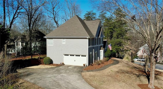 view of home's exterior with concrete driveway, a garage, and roof with shingles