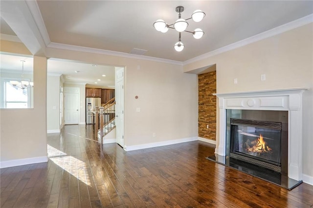 unfurnished living room featuring an inviting chandelier, crown molding, and dark hardwood / wood-style floors