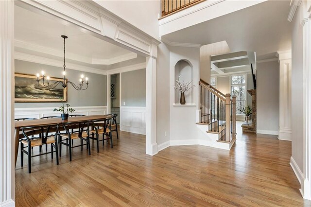 2660 Burnt Hickory Dr, Cumming, GA 30028 - dining room with light wood-type flooring, a chandelier, a decorative wall, stairs, and crown molding