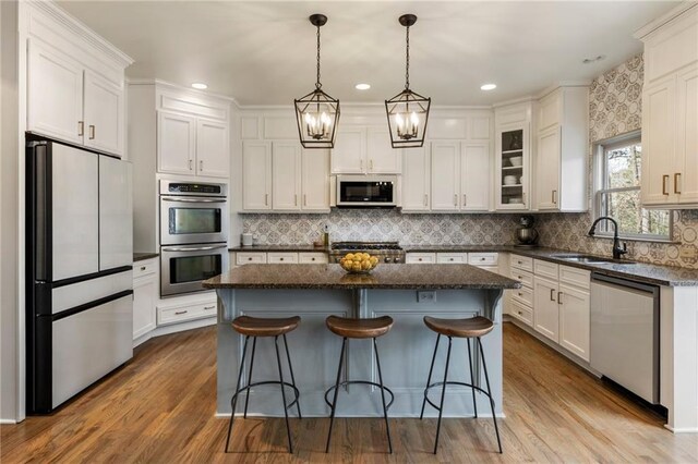 2660 Burnt Hickory Dr, Cumming, GA 30028 - kitchen with stainless steel appliances, a sink, a center island, white cabinetry, and recessed lighting