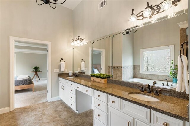 2660 Burnt Hickory Dr, Cumming, GA 30028 - ensuite bathroom with high vaulted ceiling, double vanity, tile patterned flooring, baseboards, and a bath