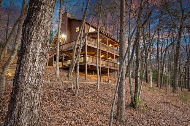 back house at dusk featuring a deck