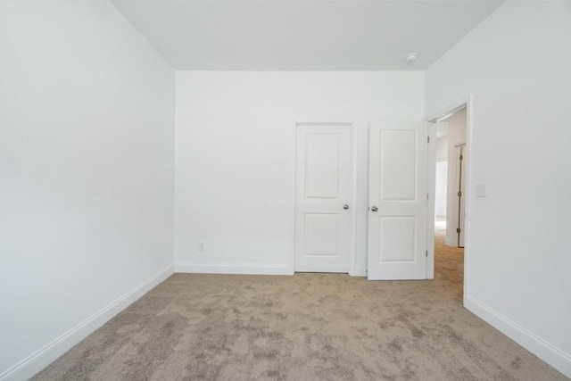 interior space featuring light carpet and baseboards