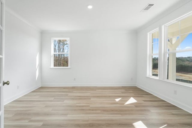 unfurnished room featuring ornamental molding, visible vents, light wood-style floors, and baseboards