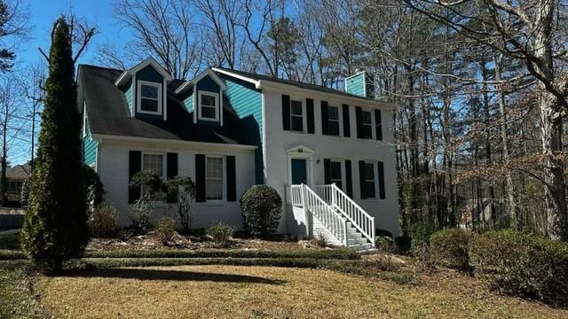 colonial inspired home featuring a front lawn