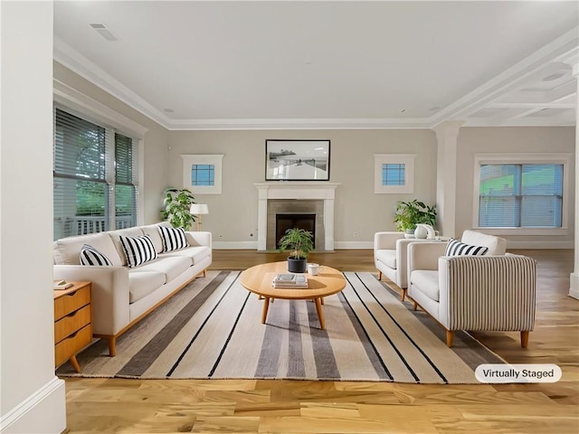 living area with visible vents, a fireplace with flush hearth, crown molding, and wood finished floors