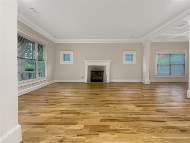 unfurnished living room featuring baseboards, a fireplace with flush hearth, plenty of natural light, and light wood-style flooring