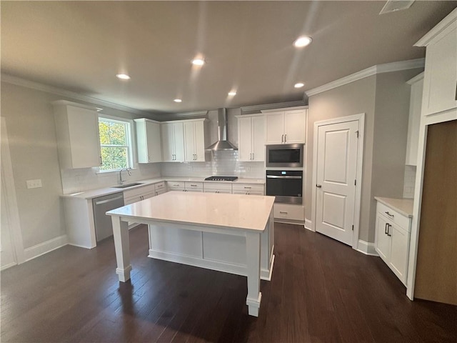 kitchen featuring wall chimney range hood, sink, dark hardwood / wood-style flooring, white cabinetry, and stainless steel appliances