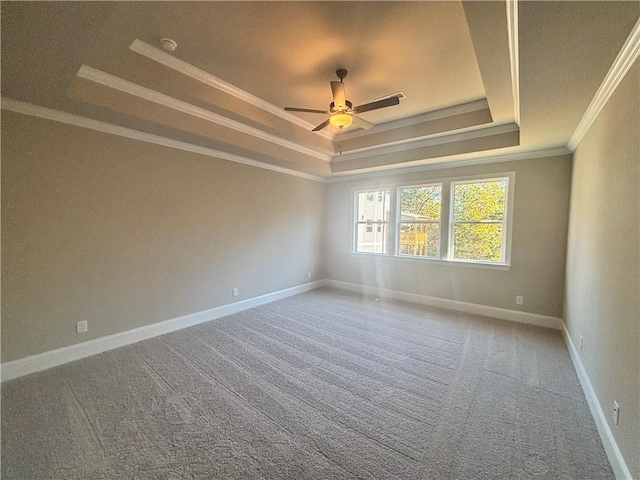 carpeted empty room featuring crown molding, a tray ceiling, and ceiling fan