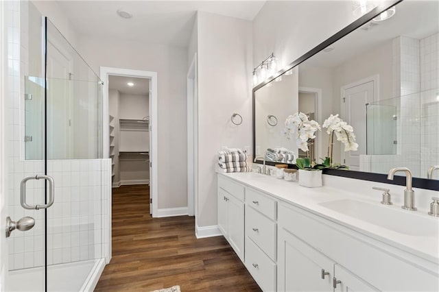 full bathroom with a sink, baseboards, a shower stall, and wood finished floors