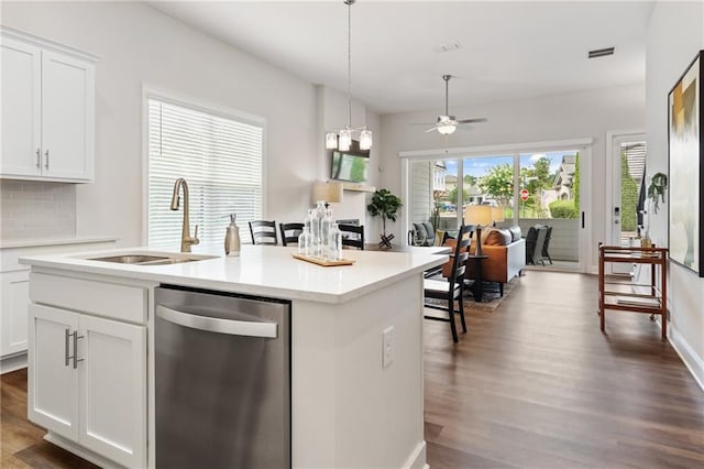 kitchen featuring visible vents, dark wood-style flooring, a center island with sink, a sink, and dishwasher