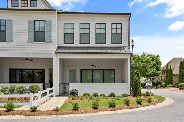 view of front of property featuring fence, a porch, a standing seam roof, a ceiling fan, and metal roof