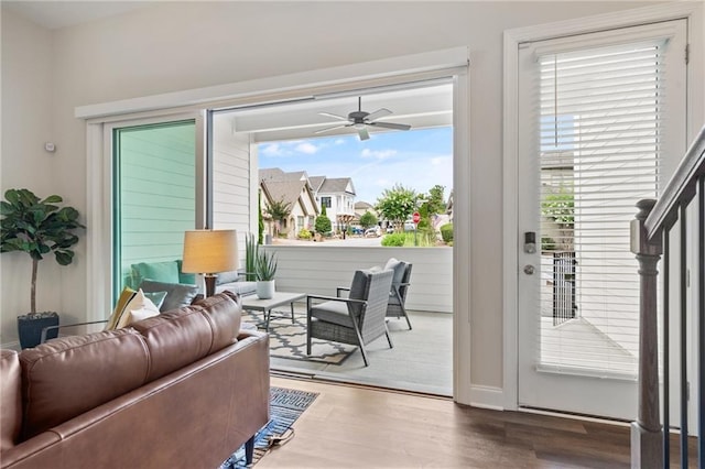 living room featuring ceiling fan, wood finished floors, and a wealth of natural light