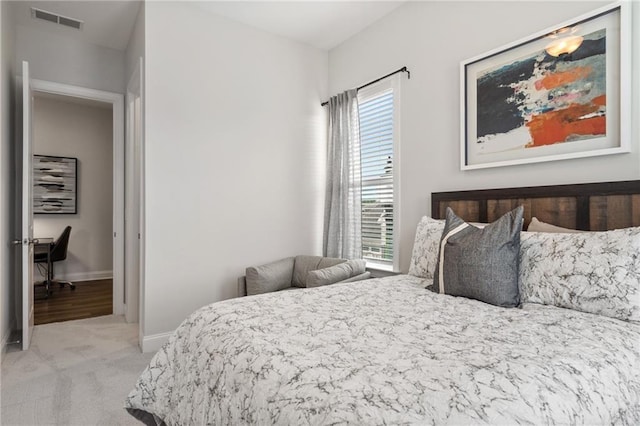 bedroom with baseboards, light colored carpet, and visible vents