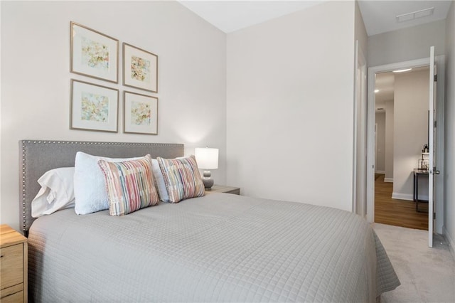 carpeted bedroom featuring visible vents