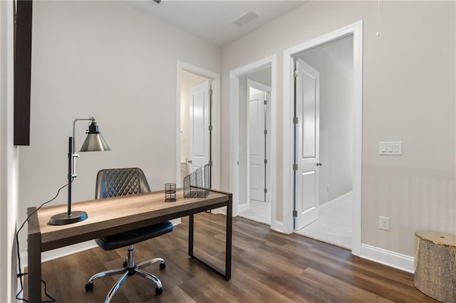 office area with visible vents, baseboards, and dark wood-type flooring