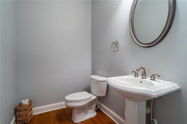 bathroom with hardwood / wood-style flooring, toilet, and sink