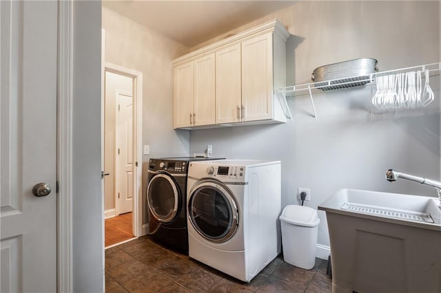 laundry room with washing machine and dryer, sink, and cabinets