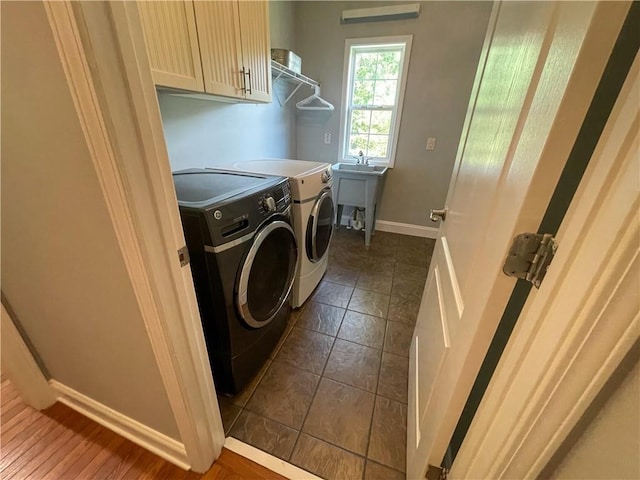 laundry area with washer and dryer, cabinets, and sink