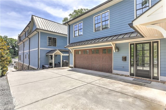 2972 Lookout Pl NE, Atlanta, GA 30305 - view of front of house featuring a standing seam roof, a garage, a metal roof, and concrete driveway