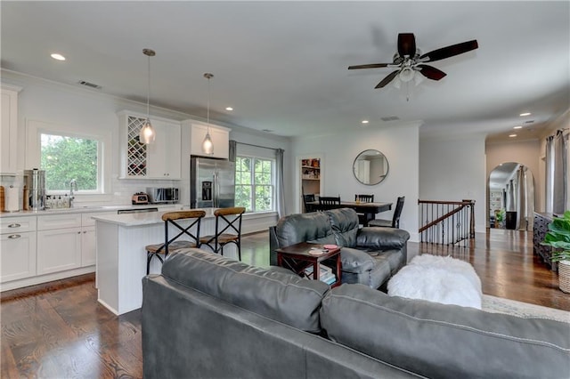 2972 Lookout Pl NE, Atlanta, GA 30305 - living room featuring dark wood-style flooring, arched walkways, a ceiling fan, recessed lighting, and crown molding