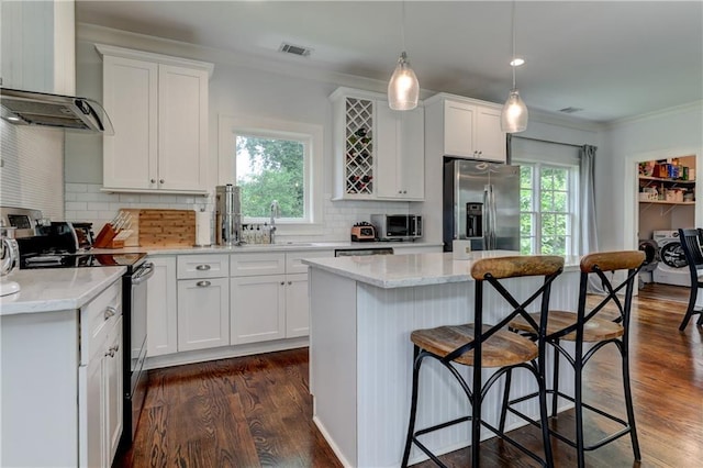 2972 Lookout Pl NE, Atlanta, GA 30305 - kitchen with stainless steel fridge, black electric range, ornamental molding, a kitchen bar, and white cabinets