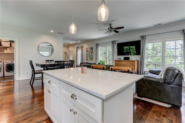 2972 Lookout Pl NE, Atlanta, GA 30305 - kitchen featuring washer and clothes dryer, open floor plan, decorative light fixtures, a kitchen island, and crown molding