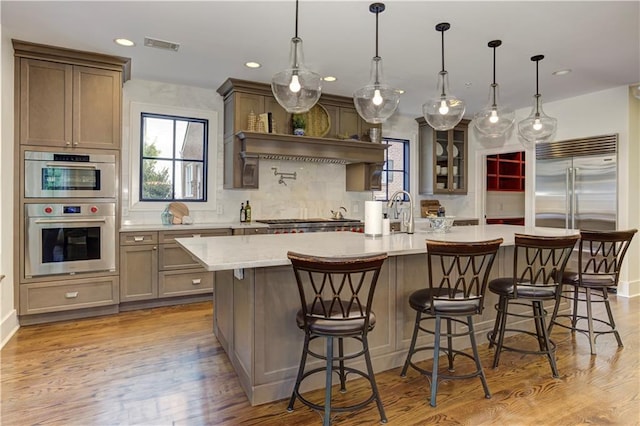 2972 Lookout Pl NE, Atlanta, GA 30305 - kitchen with stainless steel appliances, a spacious island, light wood-style flooring, recessed lighting, and tasteful backsplash